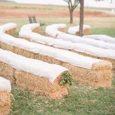 hay bales are lined up on the grass