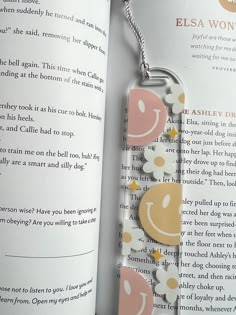 an open book with a key chain attached to it's front cover and inside pages