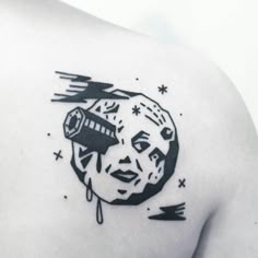 a woman's shoulder with a black and white image of the moon on it