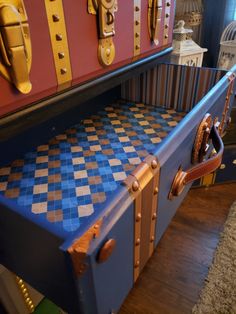 an old trunk is painted blue and gold with checkerboard design on it's sides