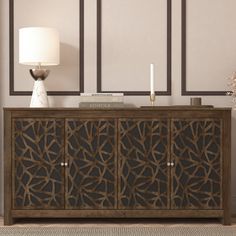 the sideboard has an intricate design on it and is next to a table with a lamp