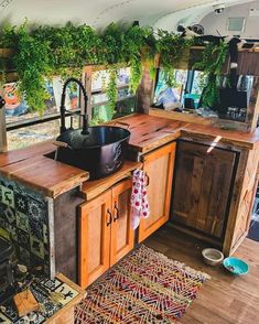 a kitchen area with wooden cabinets and a stove in the center, surrounded by potted plants