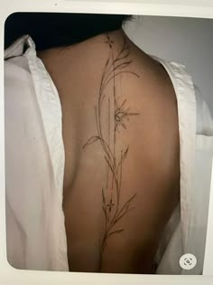 the back of a woman's shoulder with flowers on it and vines growing out of it