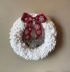 a crocheted christmas wreath hanging on the wall