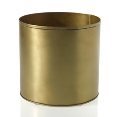 a gold colored cup is sitting on a white surface and it looks like the inside of a cylinder