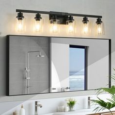 a bathroom with a large mirror and lights on the wall next to it's sink