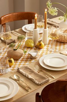 the table is set with white plates and silverware