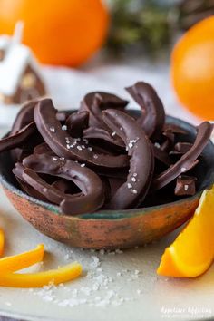 a bowl filled with chocolate frosting next to sliced oranges