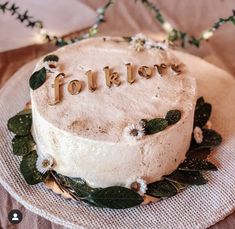 a frosted cake with the word for love spelled on it sitting on a plate