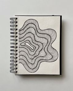 a spiral notebook with an abstract drawing on it