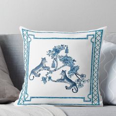 a blue and white pillow sitting on top of a couch