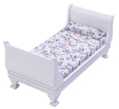 a white doll bed with flowers on the sheets and bottom half is turned upside down