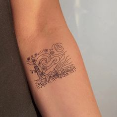 a woman's arm with a tattoo on it that has an image of a tree