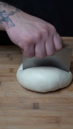 a person with a knife cutting some bread