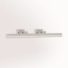 two chrome handles on a white wall