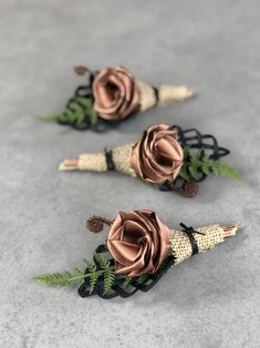 three boutonnieres with flowers on them sitting on the ground next to each other