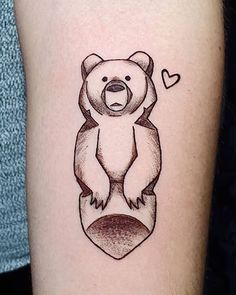 a tattoo with a bear on it's arm and a heart in the middle