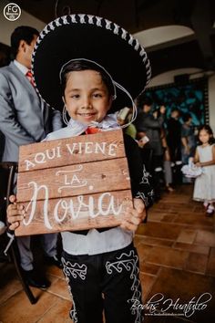 a little boy in a sombrero holding a sign that says rou viene la noivaa