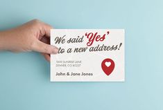 a person holding up a business card that says we said yes to a new address