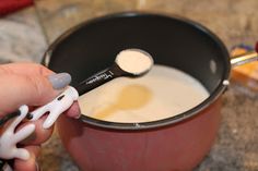 a person is using a spoon to stir something in a pot