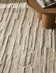 a coffee table sitting on top of a rug covered in white carpeted flooring