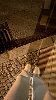 a person standing on the sidewalk with their feet up