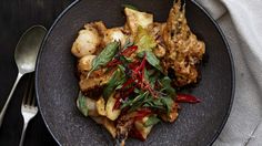 a black plate topped with meat and vegetables