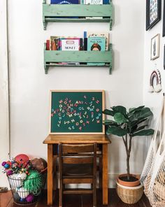 a wooden table with a chalkboard on it next to a potted plant and bookshelf