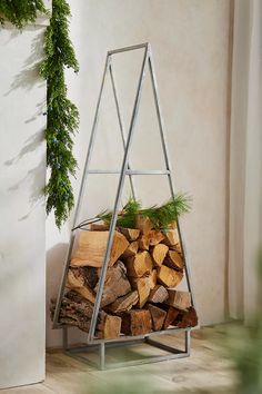 a stack of firewood sitting next to a plant