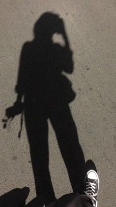 the shadow of a person standing next to a skateboard