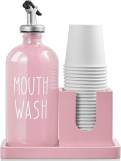 a pink bottle with a white cup on it and a pink holder for the mouthwash