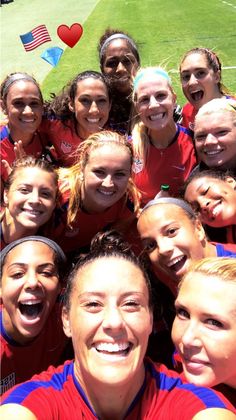 a group of women standing next to each other on top of a soccer ball field