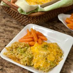 two plates filled with rice and carrots next to a basket full of other food