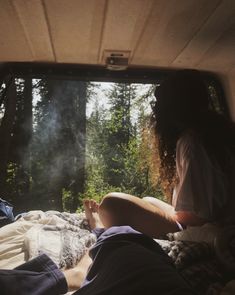 two people are sitting in the back of a truck with their feet up on the bed