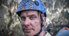 a man wearing a blue helmet and climbing gear