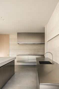 an empty kitchen with stainless steel appliances and counter tops