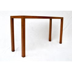 a wooden table with two legs and a white back dropper on the top, against a plain background