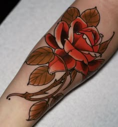 a red rose tattoo on the left arm and foot, with leaves around it's edges