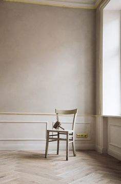 a chair sitting in an empty room next to a window