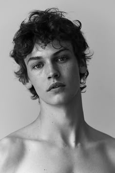 black and white photograph of a man with freckles on his chest looking at the camera