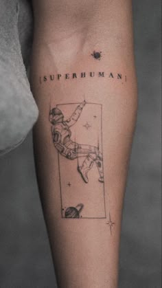 a person with a tattoo on their leg that reads, superhumani and an astronaut