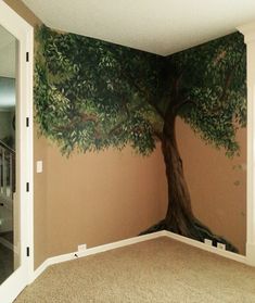 an empty room with a tree painted on the wall and carpeted flooring in front of it