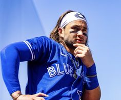 a baseball player is holding his hand on his chin and looking to the side while wearing a bandana