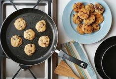 a pan filled with cookies sitting on top of a stove next to a frying pan