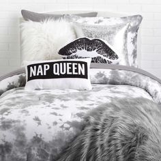 a black and white photo of a bed with a pillow that says nap queen on it