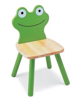 a green frog chair sitting on top of a wooden table