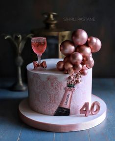 a cake decorated with grapes and a bottle of wine