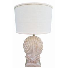 a lamp that is sitting on top of a table with a white shade over it