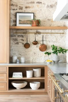 a kitchen with pots and pans hanging on the wall next to a stove top oven