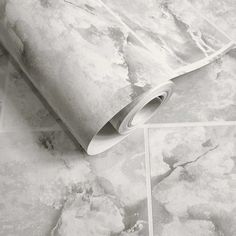 a roll of white paper sitting on top of a marble floor